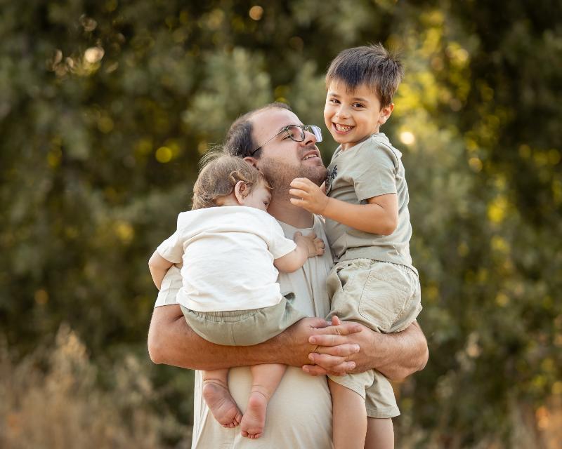 אבא מחזיק את שני הילדים בזרועותיו — צילומי גיל שנה ומשפחה